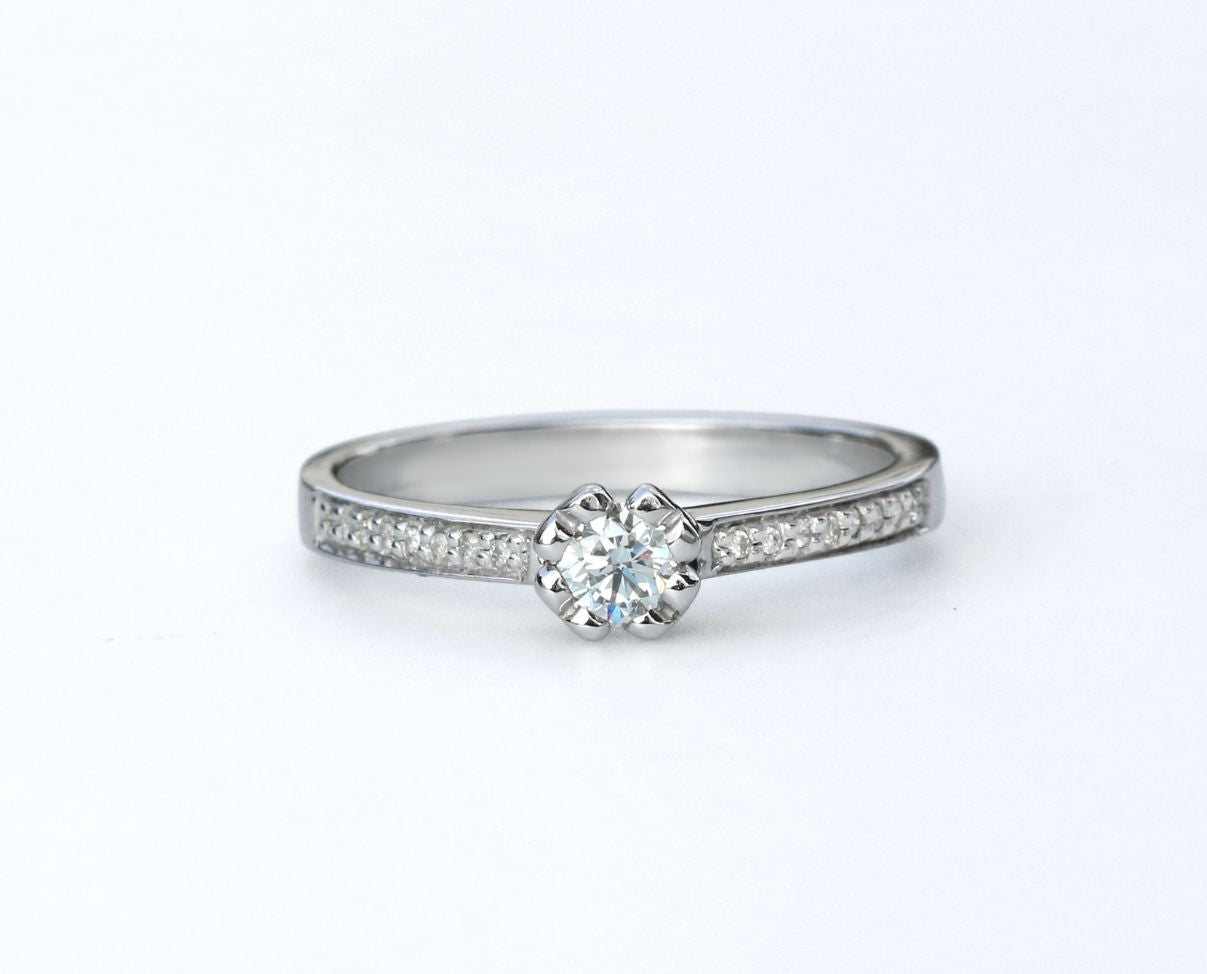 Anillo de compromiso con diamante central 0.20 ct y diamantes laterales
