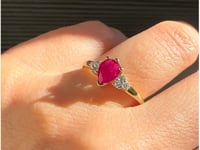 Anillo con rubí y diamantes laterales en oro amarillo