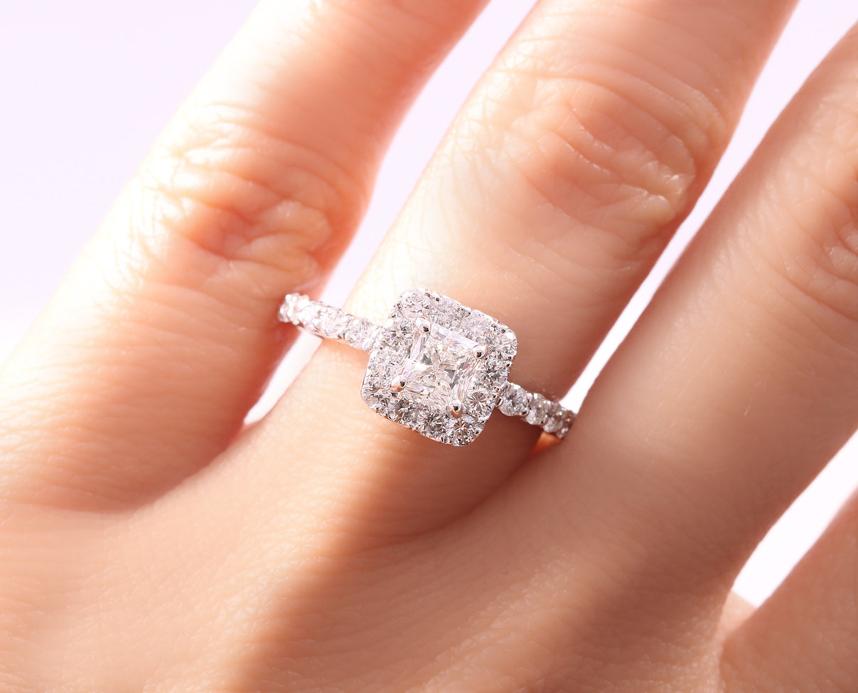 Anillo de Compromiso con diamante central princess y halo de diamantes laterales.