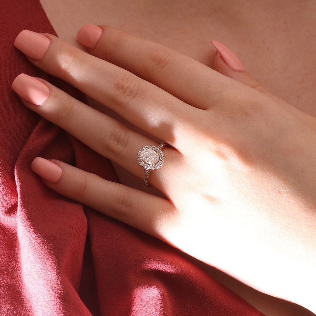 Radiante anillo de compromiso con diamante de laboratorio corte oval con halo y diamantes laterales, en oro amarillo de 18k.