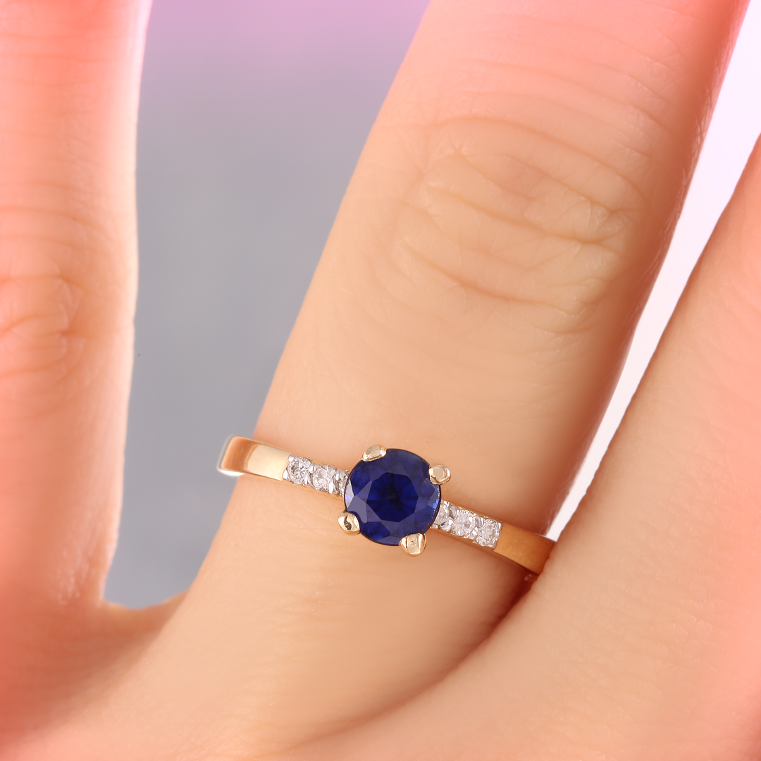 anillo de compromiso con zafiro y diamantes laterales. 
