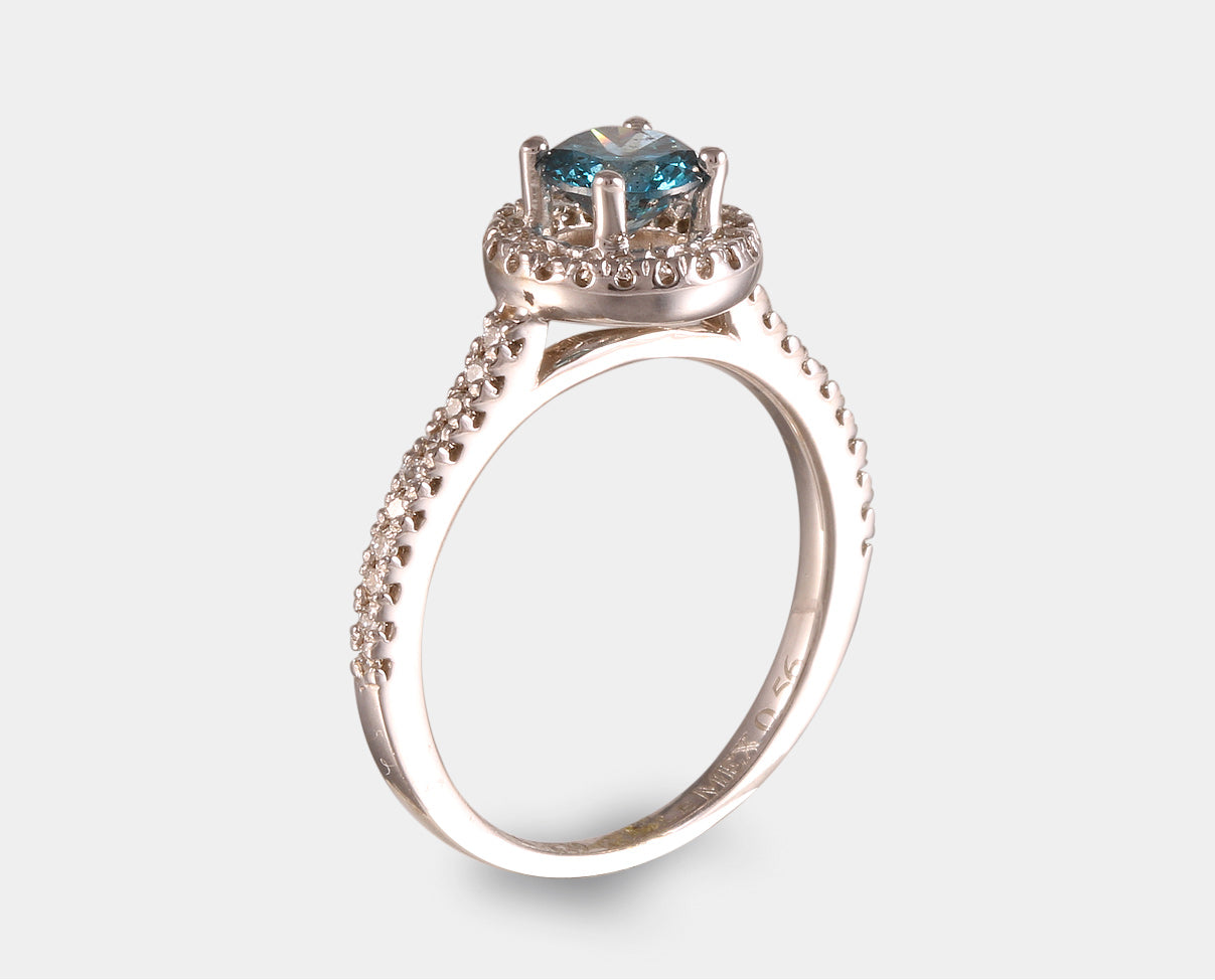 Anillo de Compromiso con diamante central azul con halo y diamantes laterales en oro blanco de 14 k. 