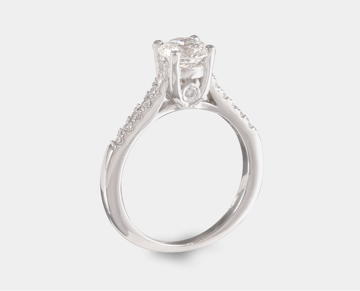 Anillo de Compromiso con diamante central corte brillante y diamantes laterales en oro blanco de 14k  