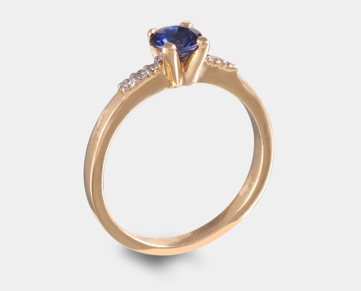 anillo de compromiso con zafiro y diamantes laterales. 