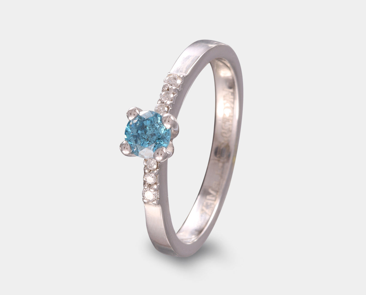 anillo de compromiso con diamante central azul y diamantes lataerales