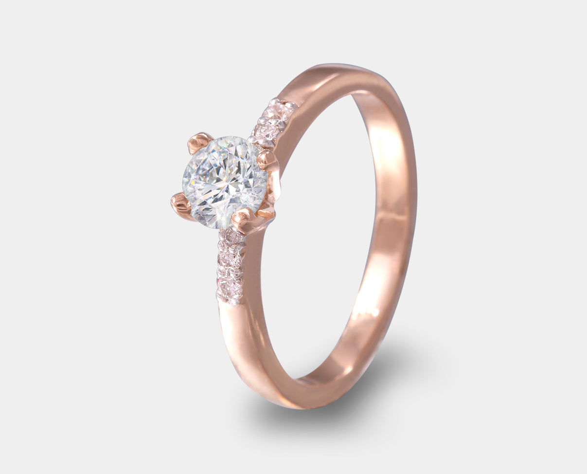anillo de compromiso oro rosa con diamante central y laterales en 14k. 